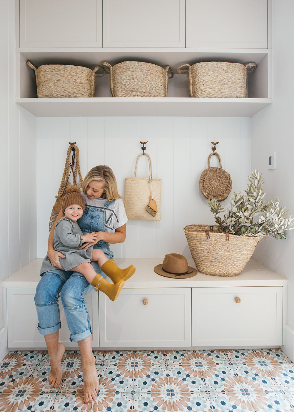 Woven baskets in Kara Demmrich's mudroom. Kara & her son playing in the foreground. 