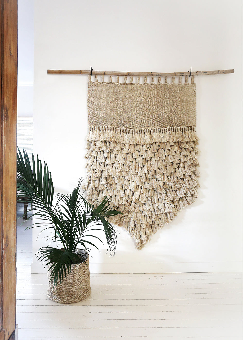 woven wall hangings - how they enhance any space. Natural jute tassel jumbo wall hanging on white wall.