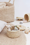 small palm leaf basket with children&#39;s toys on jute rug