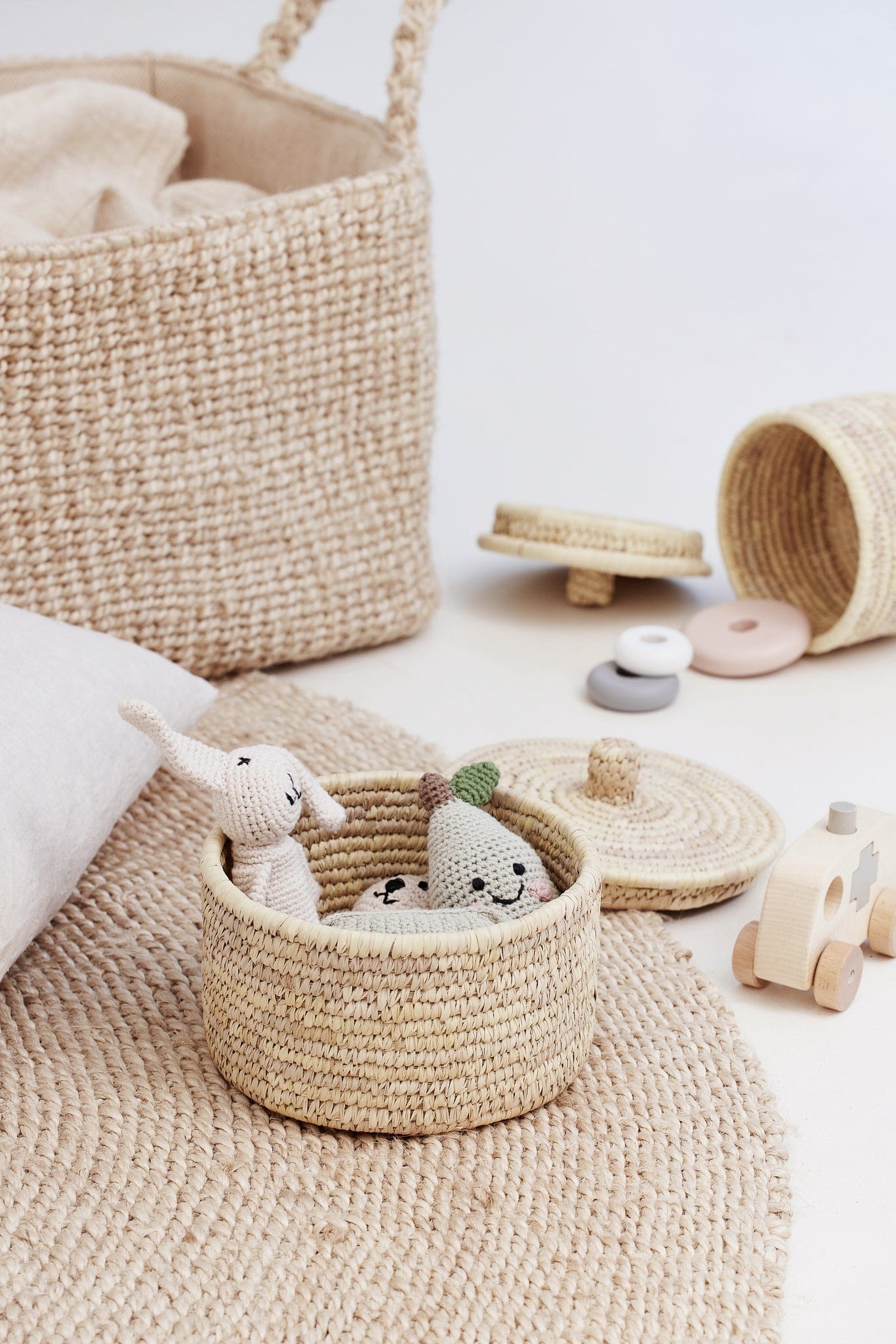 small palm leaf basket with children's toys on jute rug